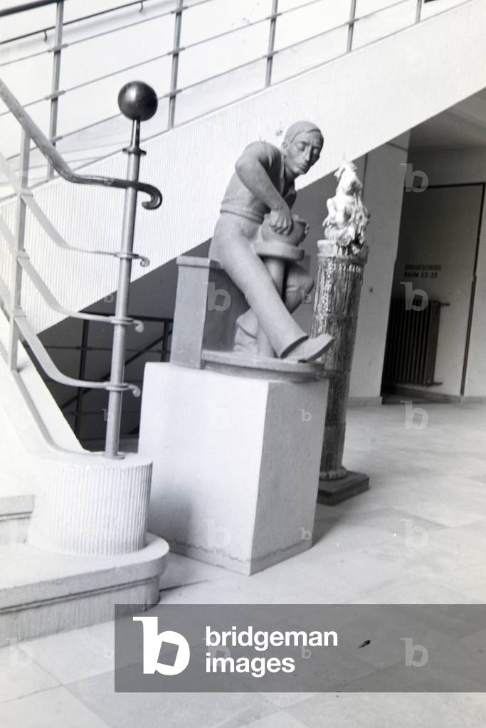 The sculpture of a ceramist in the hallway of the College for Ceramics in Höhr-Grenzhausen, Germany 1930s (b/w photo)