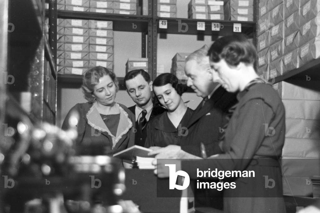 Travellers and staff members at a huge office of a travel agency in Berlin, Germany 1930s (b/w photo)