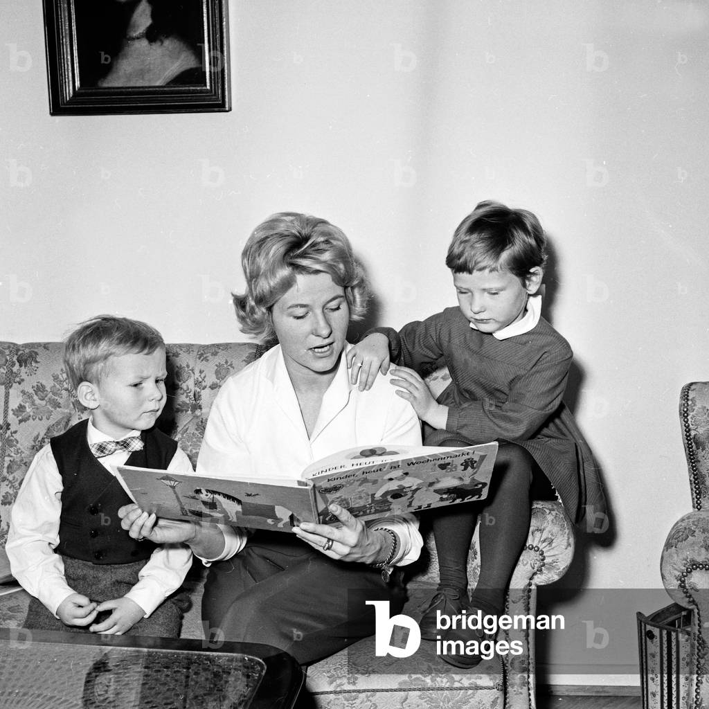 A mother reading a story to her children, Germany 1960s