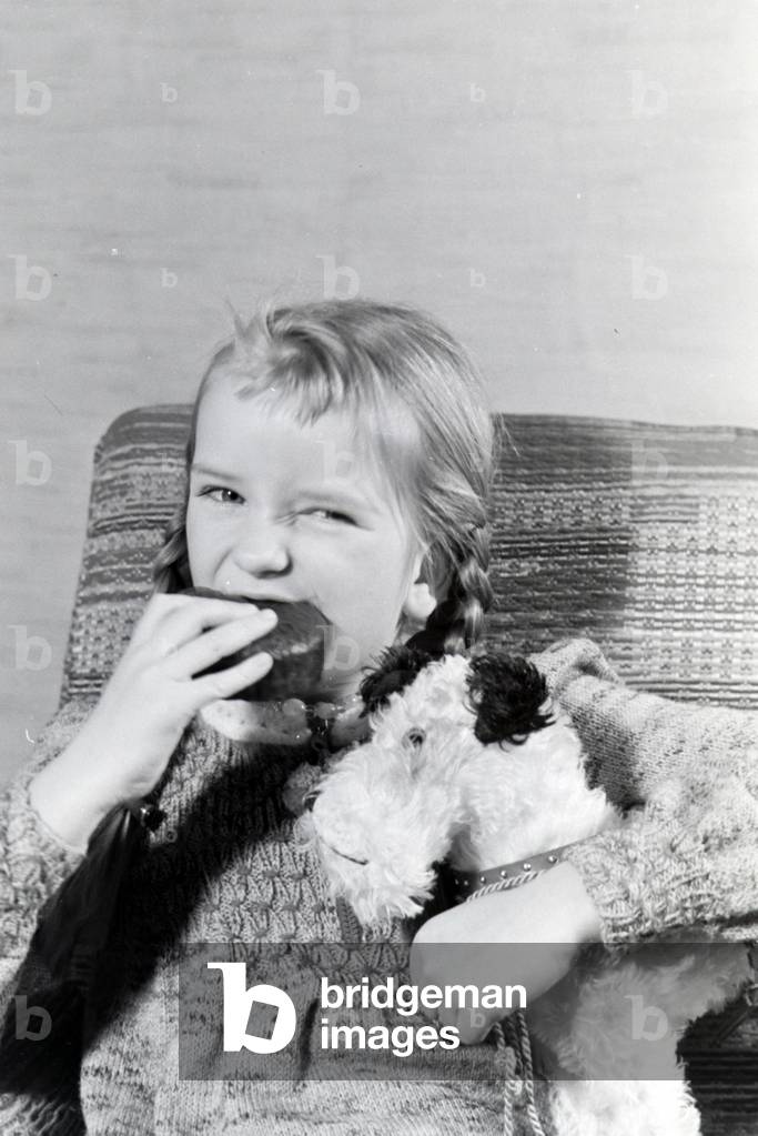 A girl eating Liegnitzer Bomben, Germany 1930s (b/w photo)