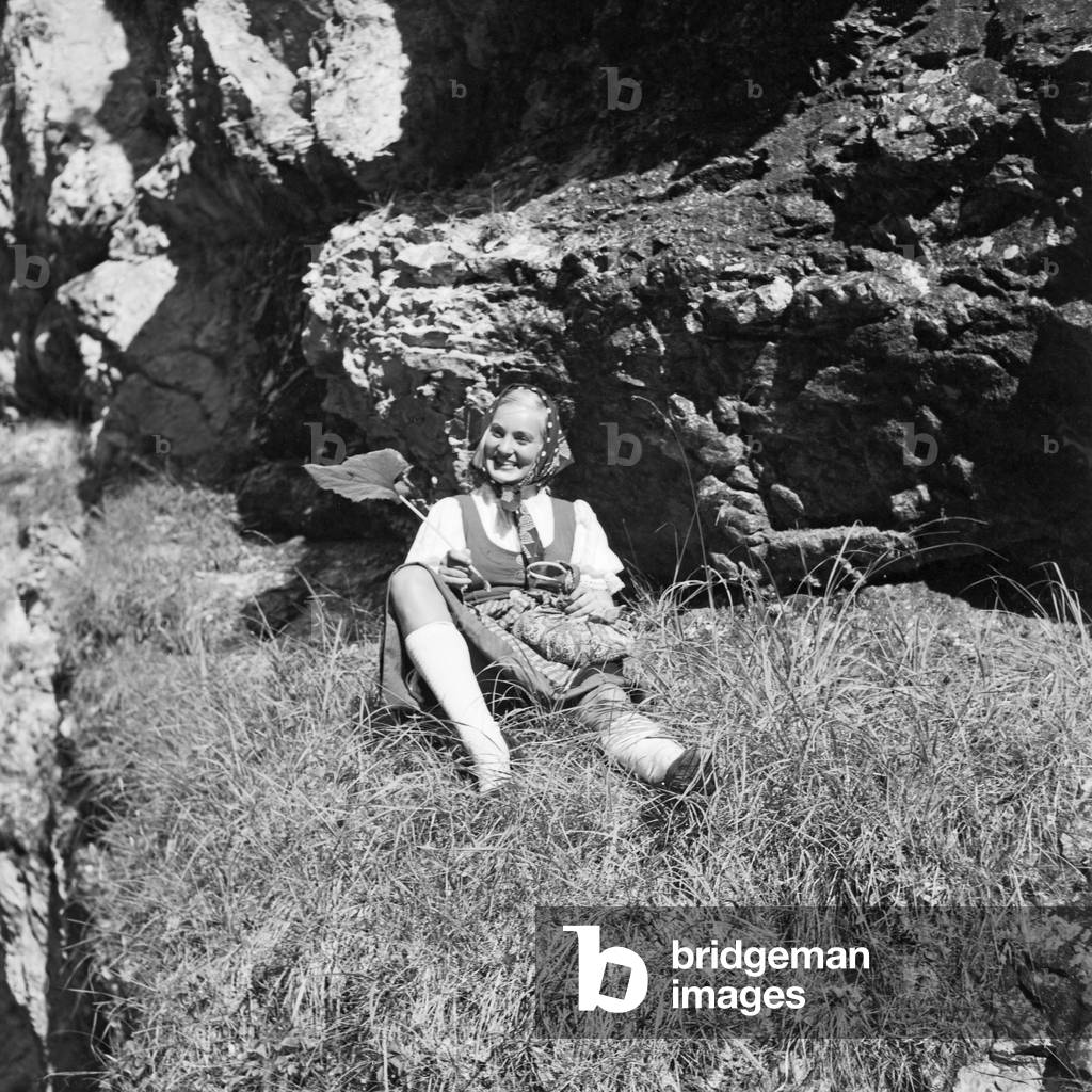 A young woman climbing on a mountain in the Wachau area in Austria, Germany 1930s (b/w photo)
