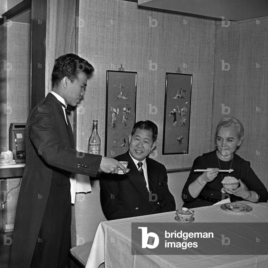 Student from abroad doing his waiter job at a Chinese restaurant at Hamburg, Germany 1960s