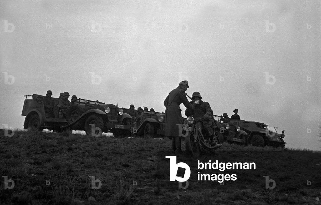 A dispatch rider delivering an important message to officers at a military training ground, Germany 1930s (b/w photo)