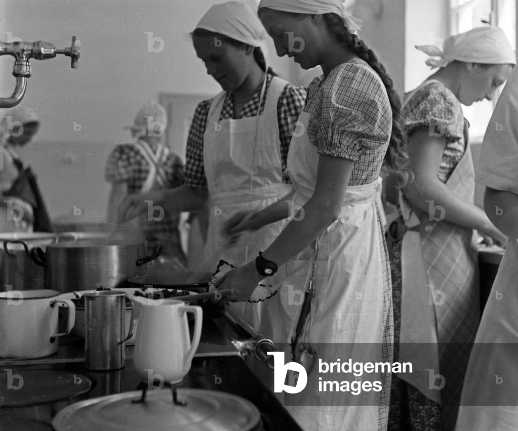 BdM girls learning how to cook at the kitchen of the school for home economics at Greifenberg, Germany 1930s (b/w photo)