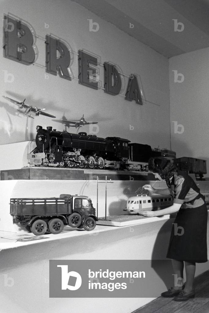 A visitor in front of a stand with models of the italian mechanical engineering corporation Breda on the Leipziger Frühjahrsmesse, Germany 1941 (b/w photo)
