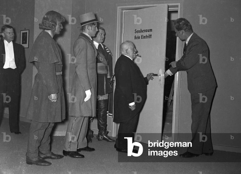 A music crew around a musician at the broadcasting building in Berlin, Germany 1930s (b/w photo)