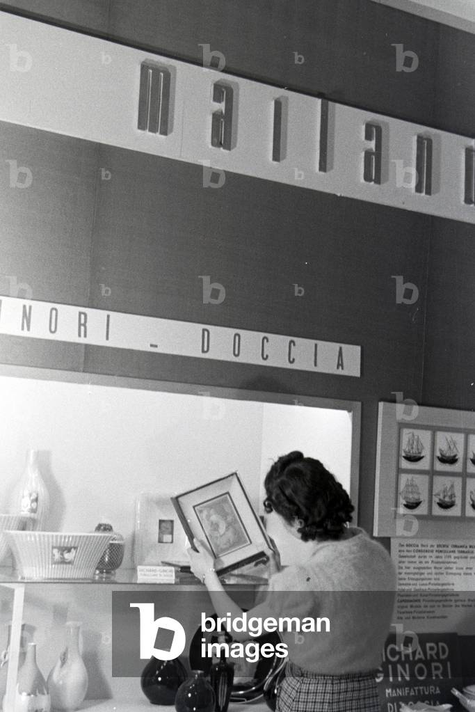 A visitor of the Leipziger Frühjahrsmesse in front of a stand of the porcelain factory Richard Ginori, Germany 1941 (b/w photo)
