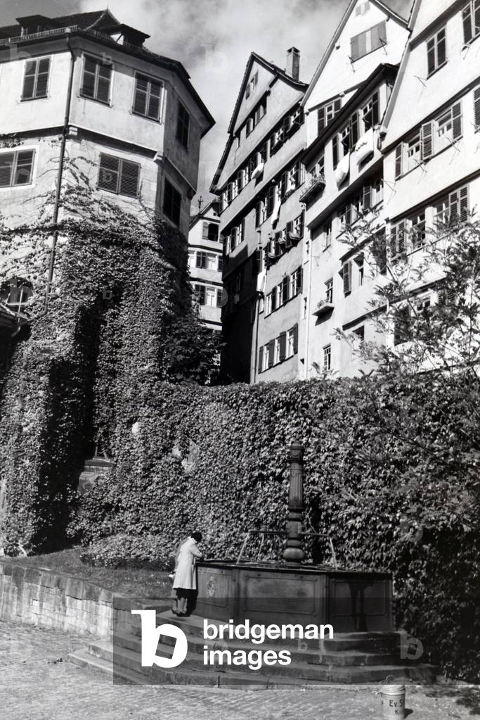 The water well with inscription on the patio of the Protestant church foundation, Tübingen, Germany 1930s (b/w photo)