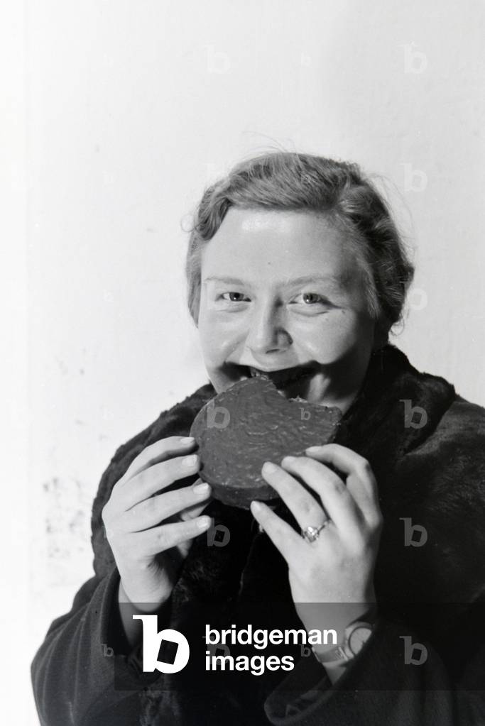 A customer tasting gingerbread, Germany 1930s (b/w photo)