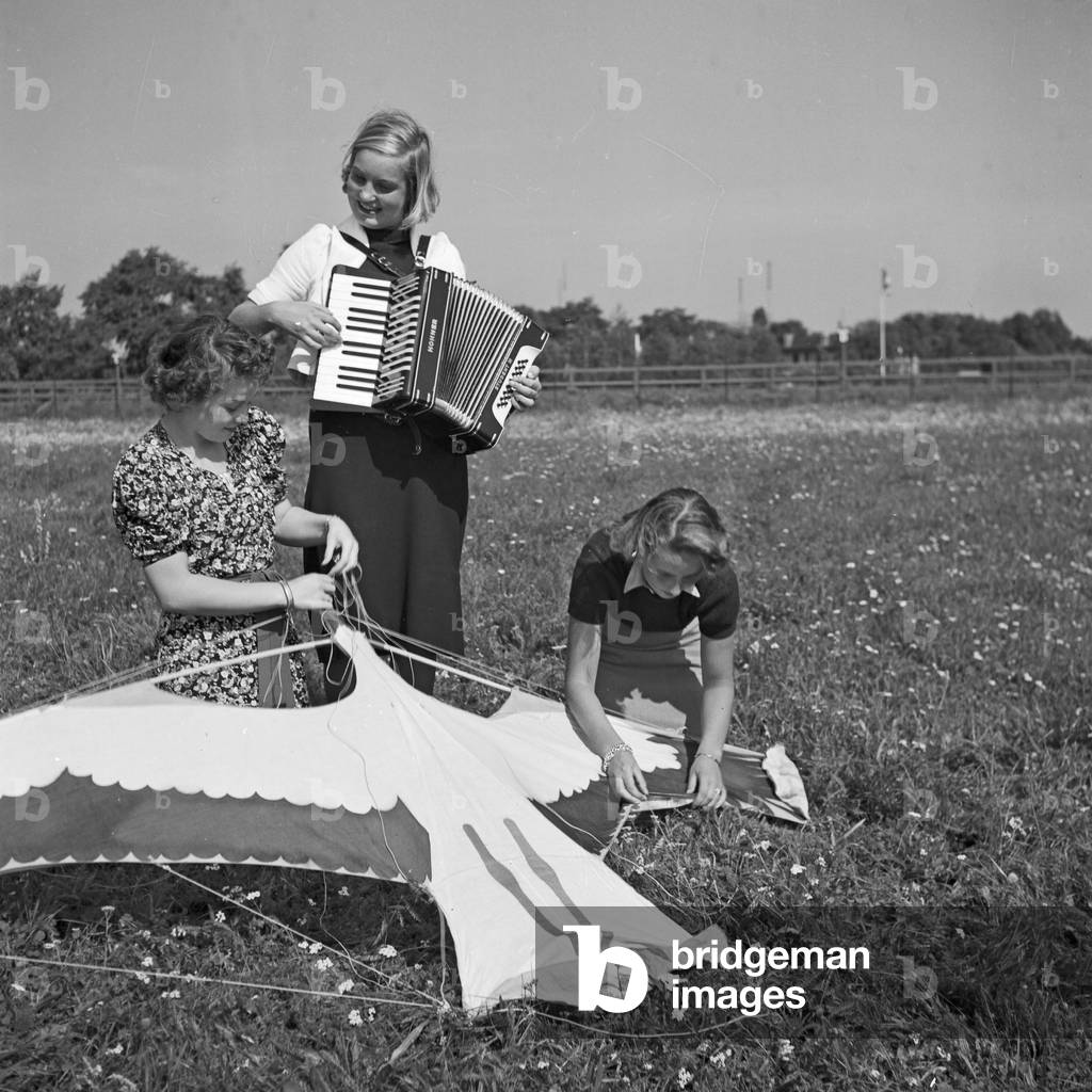 Three women playing music with an accordion, Germany 1930s (b/w photo)