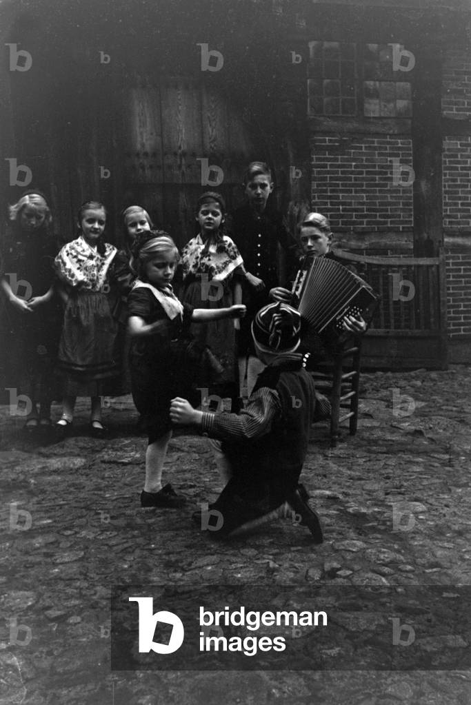 Children dancing in traditional costume of Ammerland near Bad Zwischenahn at the Oldenburg area, Germany 1930s (b/w photo)
