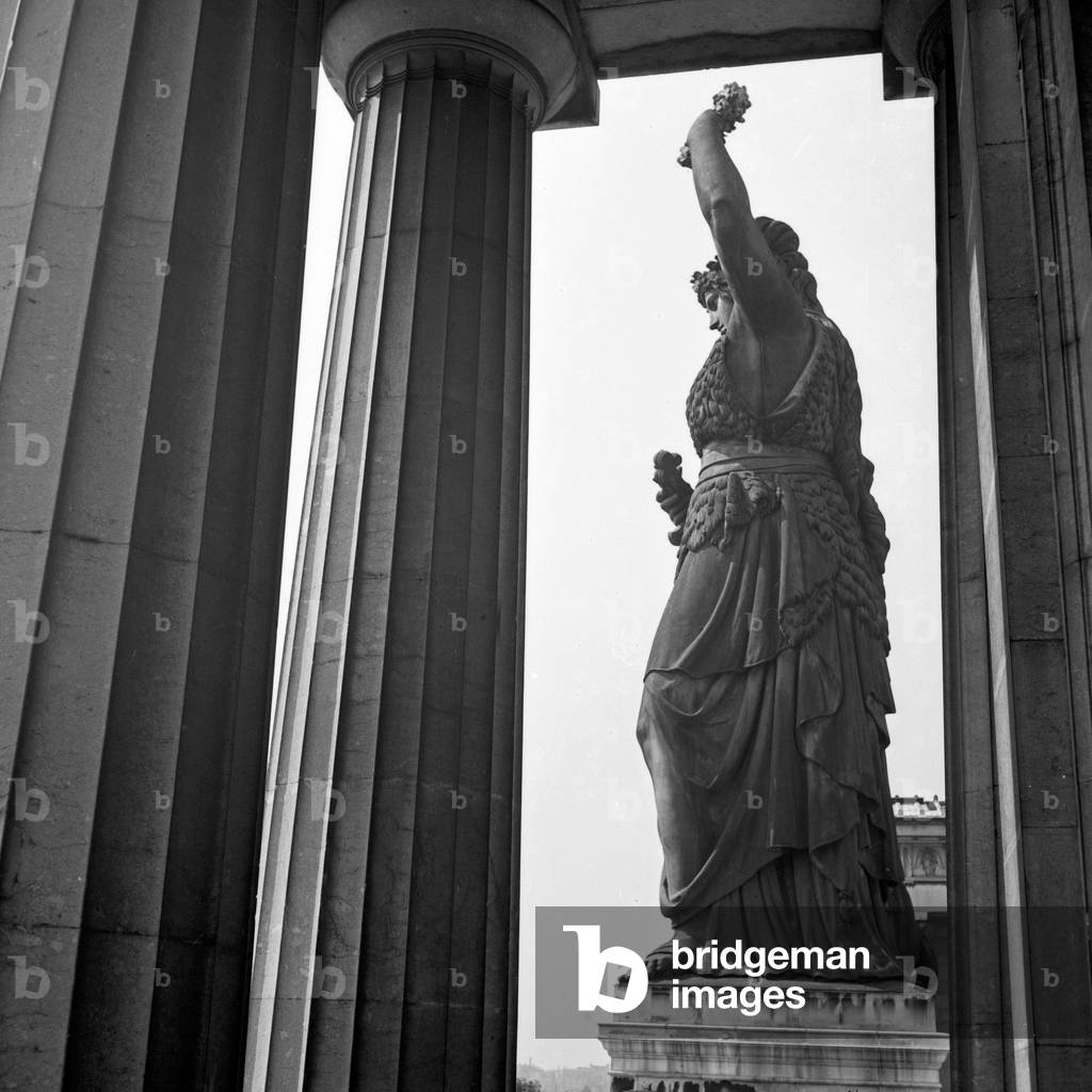 Side view of the Bavaria statue from between the columns of the Ruhmeshalle hall of fame at Munich, Germany 1930s (b/w photo)
