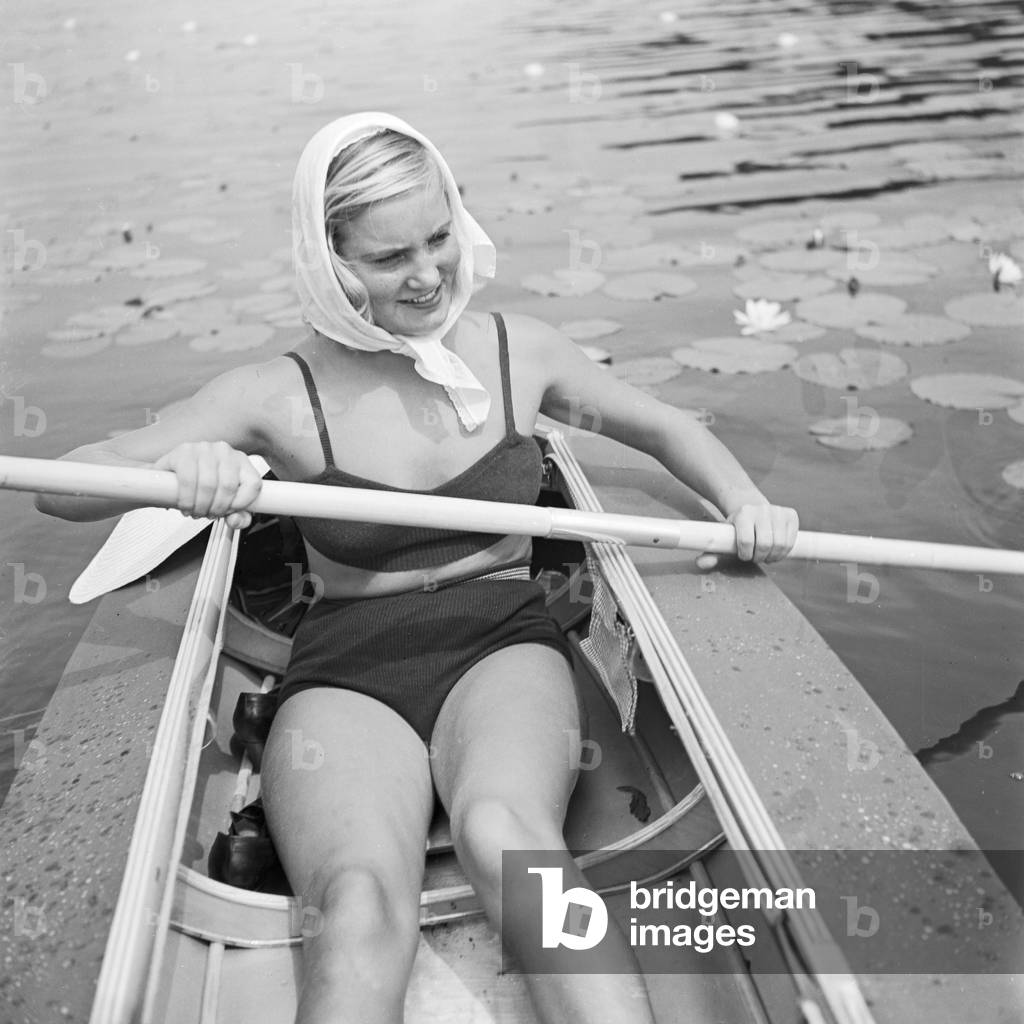 A young woman with her folding boat in the reed of a lake in the Wachau area, Germany 1930s (b/w photo)