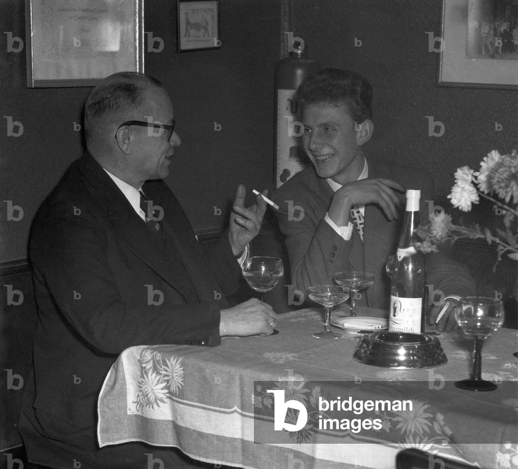Two men chatting while having a bottle of Liebfraumilch wine, Germany, 1954