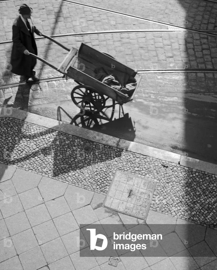 A man with a push cart in the streets of Berlin, Germany 1930s (b/w photo)