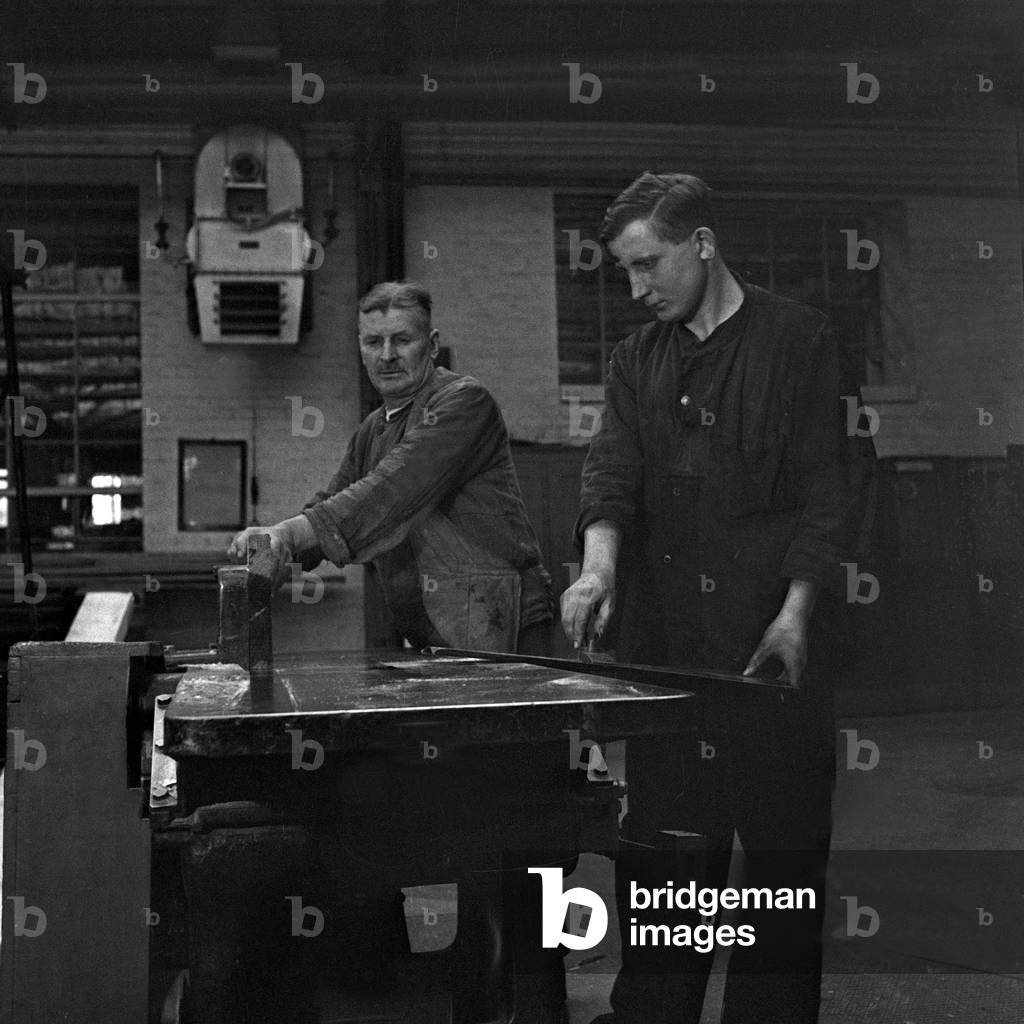 Two workers at their working place at a roll thread factory, Germany 1930s (b/w photo)