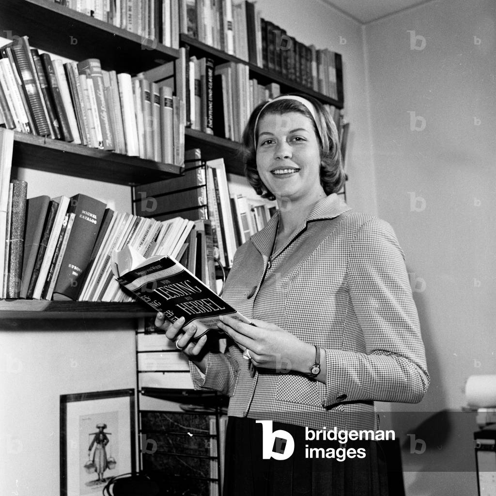 A young woman combining job and family life with her baby and her office work, Germany 1960s