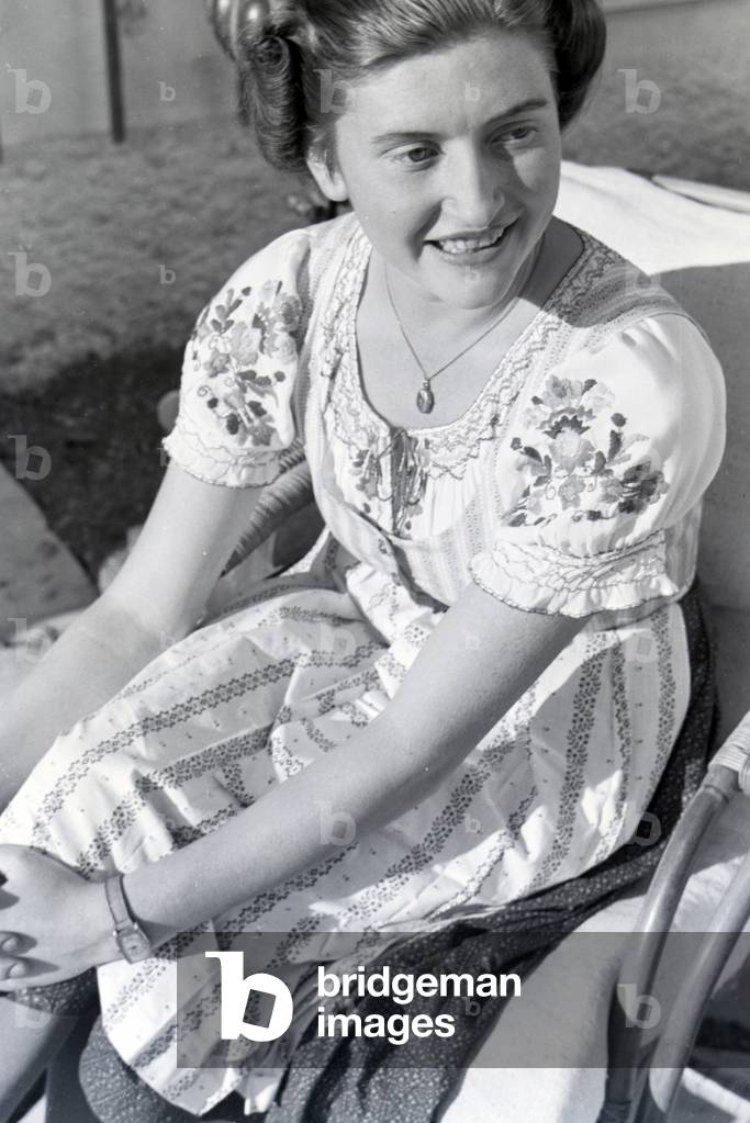 Portrait of the wife of sculptor Josef Thorak on the terace of their residence Hartmannsberg castle wearing a raditional dirndl, Germany 1930er Jahre (b/w photo)