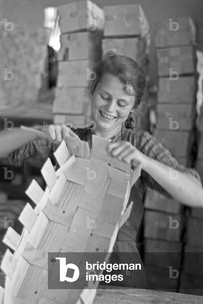 Female worker at the factory building of the basket factory, producing the baskets for the strawberry harvest at Buehl, Germany 1930s (b/w photo)