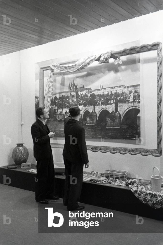 Visitors of the Leipziger Frühjahrsmesse in front of a panoramic photography of the city Prague, Germany 1941 (b/w photo)