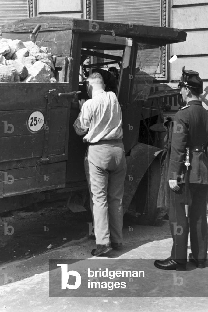 A policeman checking a driving licence at a traffic accident, Germany 1930s (b/w photo)