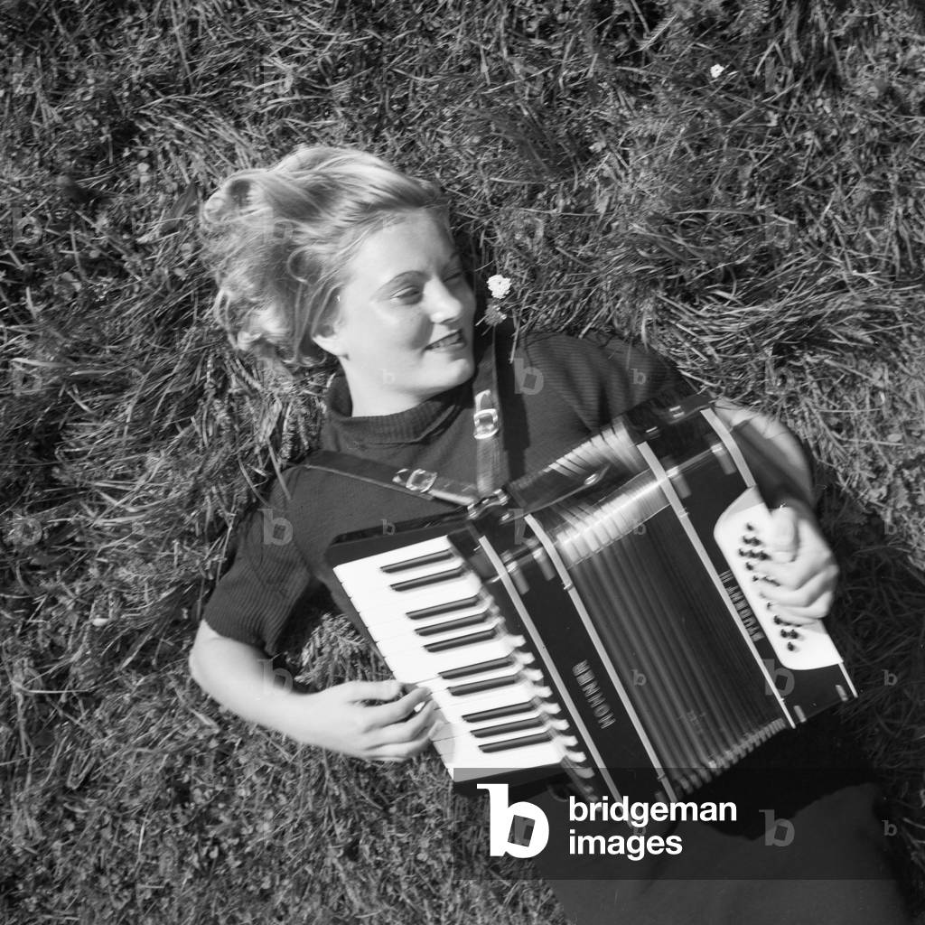 A young woman playing an accordion, Germany 1930s (b/w photo)