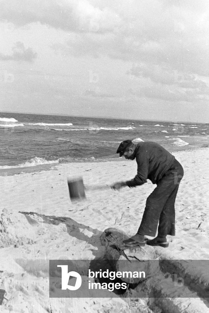 Bath attendant working on the beach at the Baltic Sea, Germany 1930s (b/w photo)