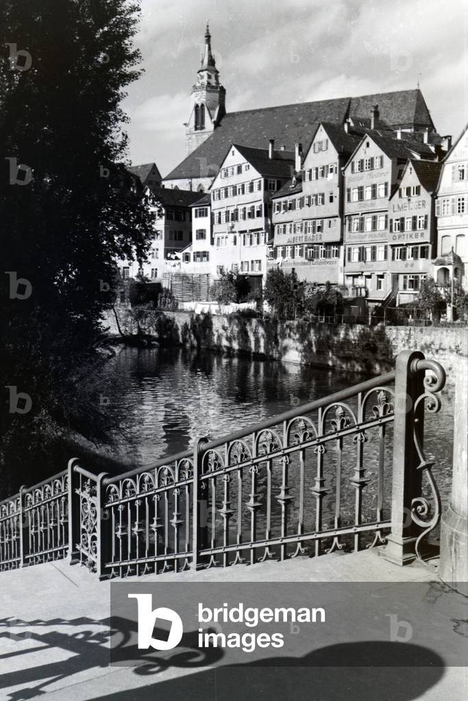 The facades of half-timbered houses along the Neckar with the collegiate church in the background in Tübingen, Germany 1930s (b/w photo)