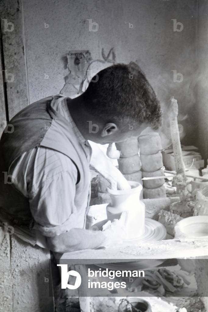 A master potter working on stoneware jars with the pottery wheel in the Kannenbäckerland, Germany 1930s (b/w photo)