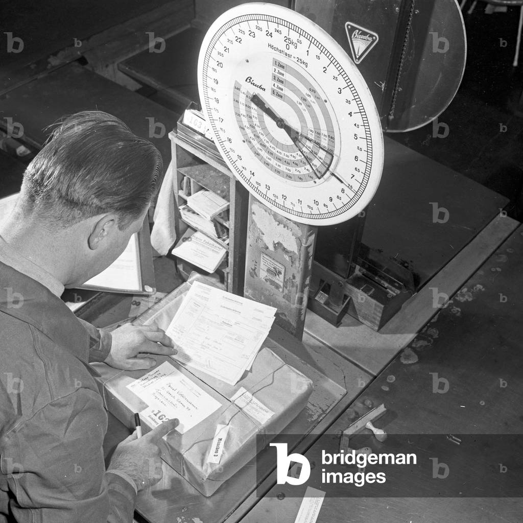 Photo coverage about every day work at German postal service Deutsche Bundespost, weighing a package, Germany 1960s