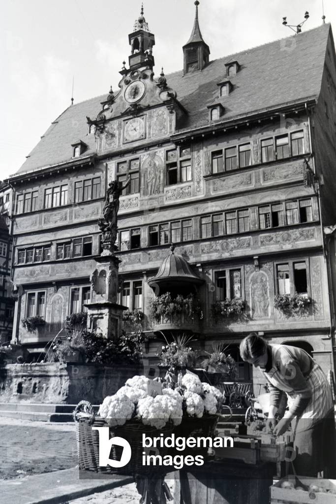 The vegetable market in front of the city hall with the astronomical clock on the market square in Tübingen, Germany 1930s (b/w photo)