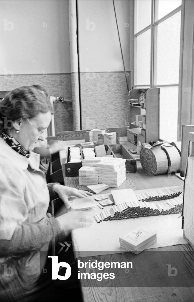 Female staff member packing cigarette packs at the Kyriazi cigarette factory at Hamburg, Germany 1930s (b/w photo)