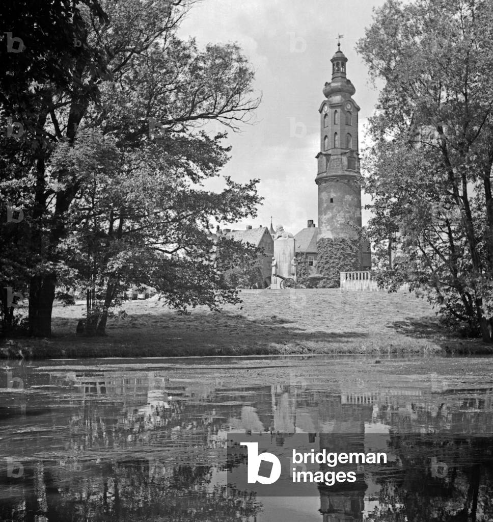 The tower of the Residenzschloss in a reflection on the water of a lake at Weimar, Germany 1930s (b/w photo)