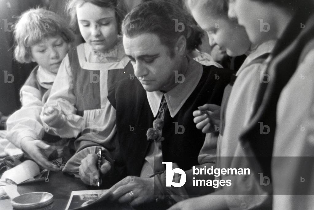 A opera singer signing autographs in the opera in Rome, Italy 1940s (b/w photo)