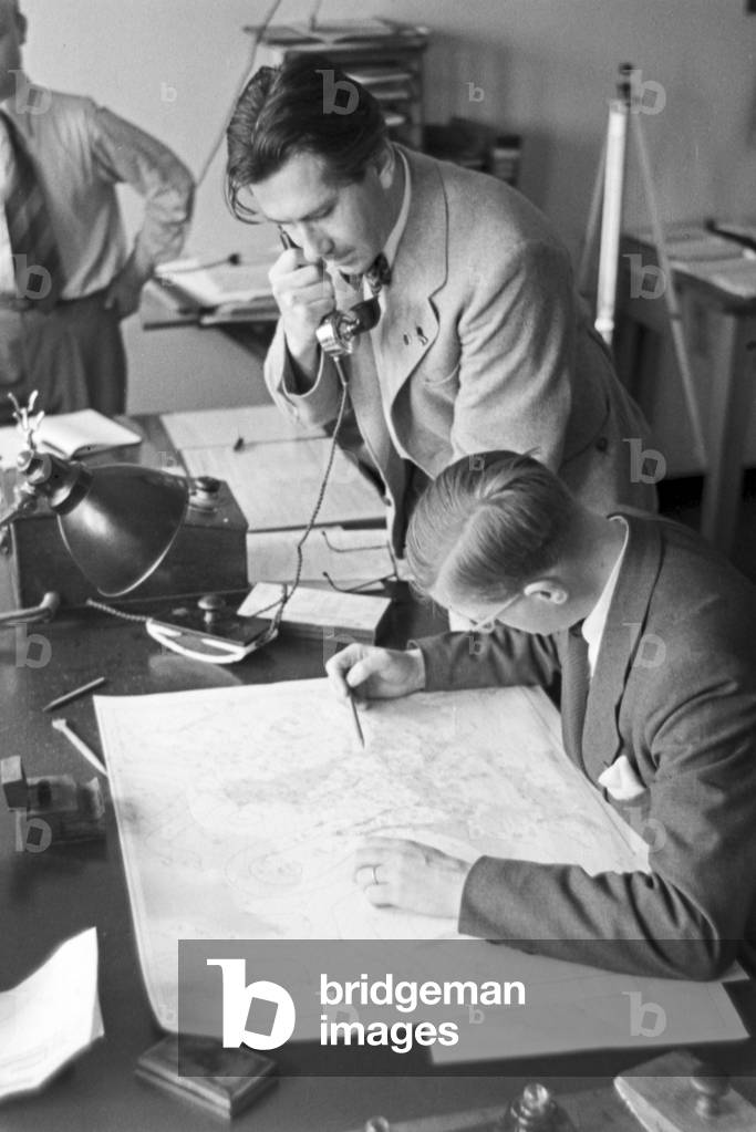 Staff member of a meteorological office drawing a card for a weather forecast, Germany 1930s (b/w photo)