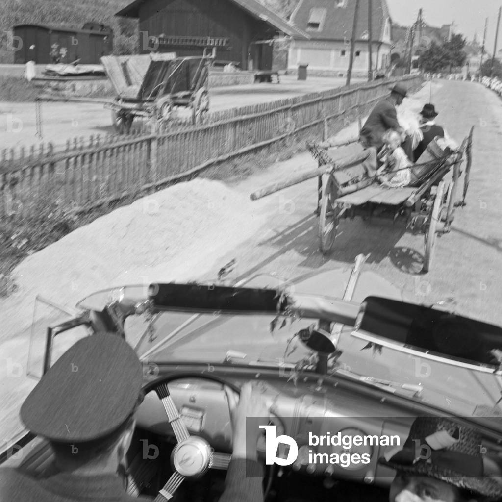 A horse carriage in front of an Opel model Admiral, Germany 1930s (b/w photo)