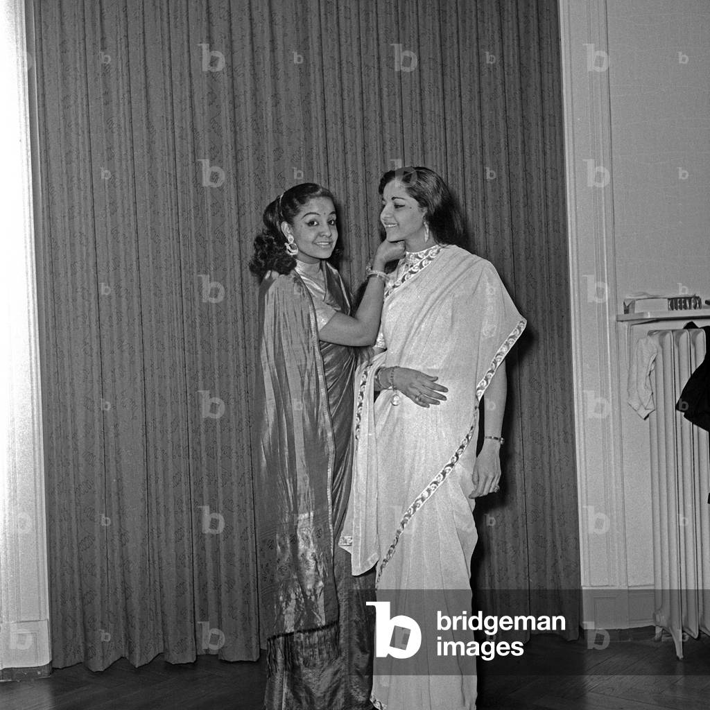 Mona Baptiste and a young Indian woman presenting new sari dresses, Germany 1950s
