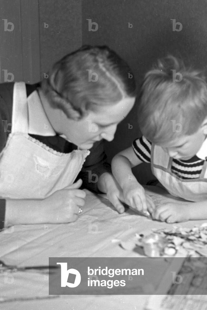 Mother and child doing handicrafts, Germany 1930s (b/w photo)