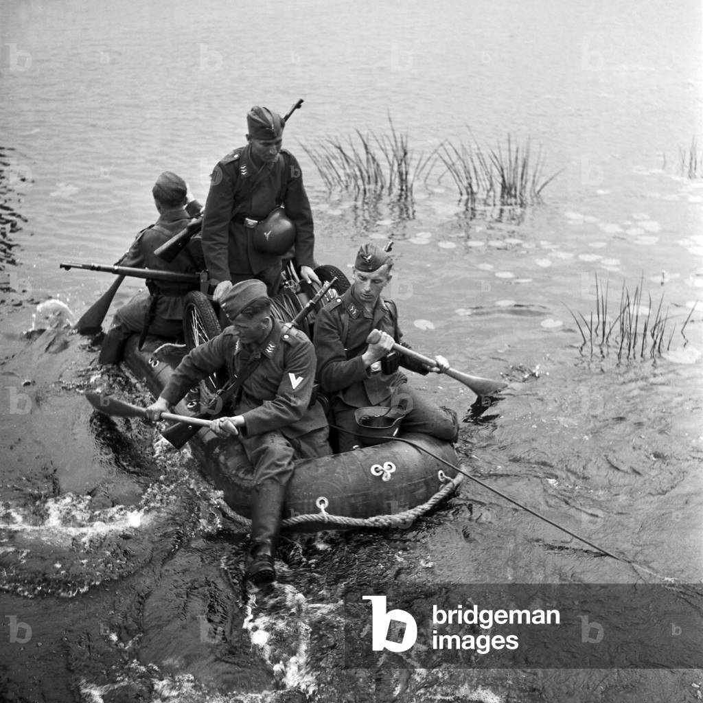 Telephone group installing a wire on the river, Germany 1940s (b/w photo)