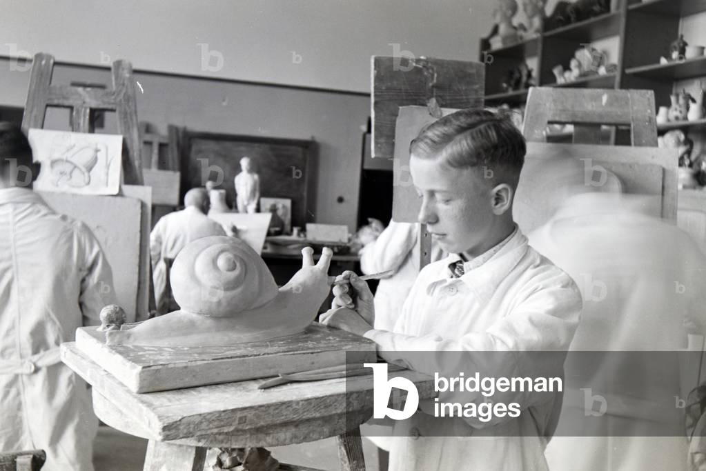 A student of the College for Ceramics working on a snail in the ateliers, Höhr-Grenzhausen, Germany 1930s (b/w photo)