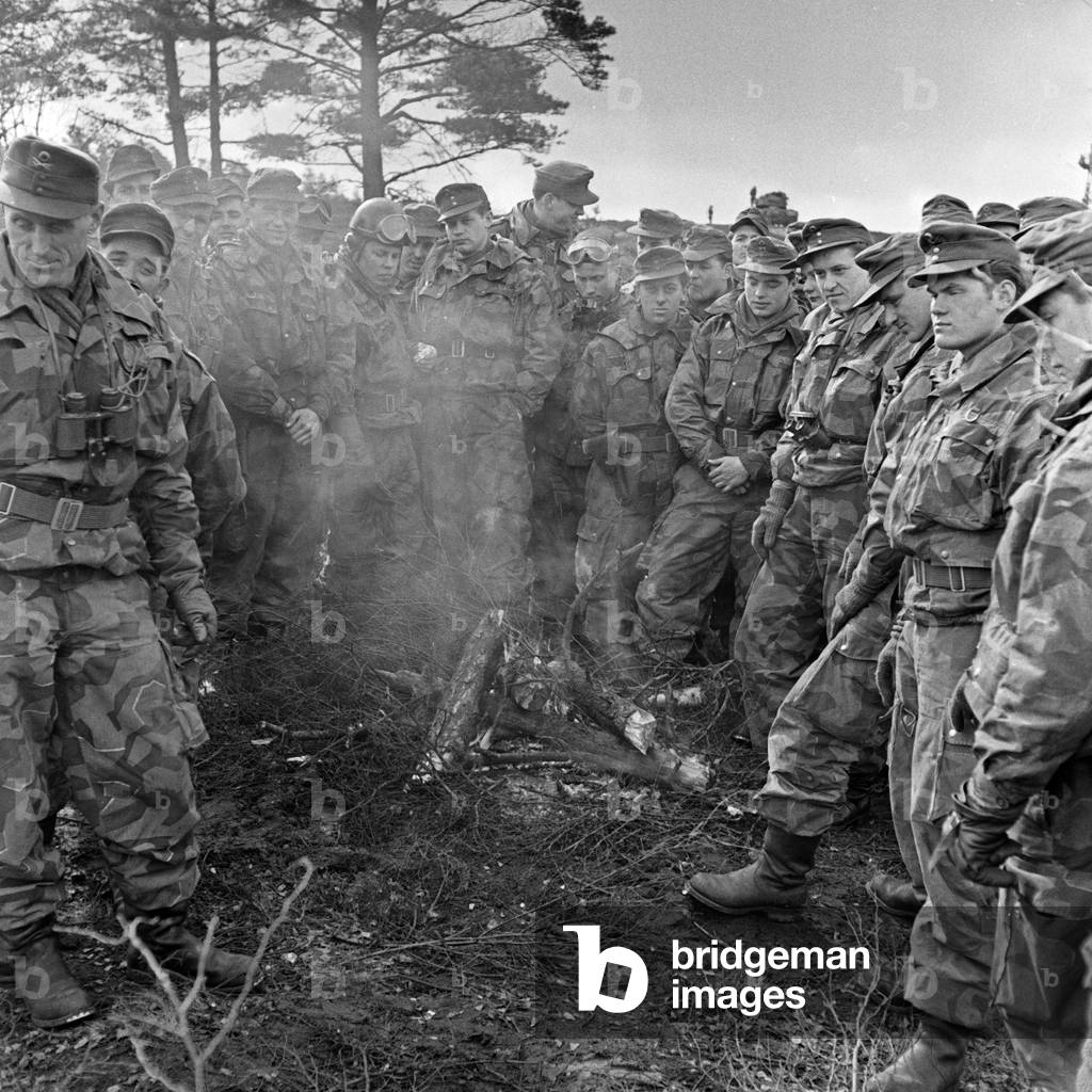 Soldiers at the camp fire discussing the results of a military exercise, Germany 1950s
