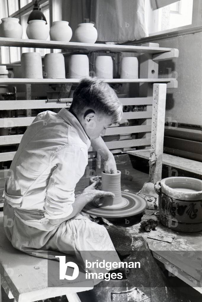 A student of the College for Ceramics working on the pottery wheel in the working ateliers, Höhr-Grenzhausen, Germany 1930s (b/w photo)