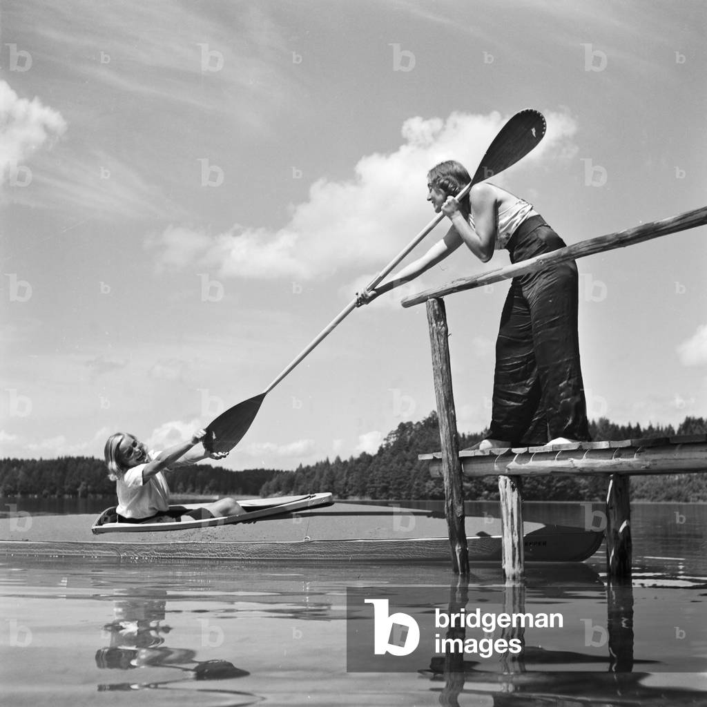 Two young women at a boardwalk on the shore of a lake in the Wachau area, Germany 1930s (b/w photo)