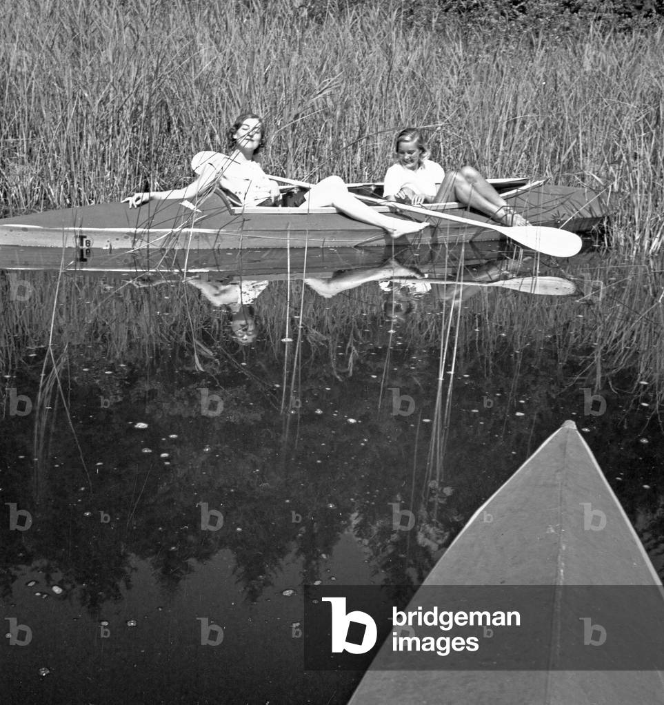 Two young women at a boardwalk on the shore of a lake in the Wachau area, Germany 1930s (b/w photo)