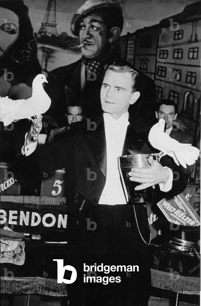 The magician takes white pigeons out of the champagne bucket on stage of a nightclub at Hamburg Reeperbahn, 1950s