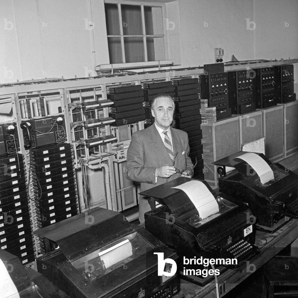 Workaday life at German radio and TV station NDR: a staff member receives breaking news from a teletyper, Germany 1950s