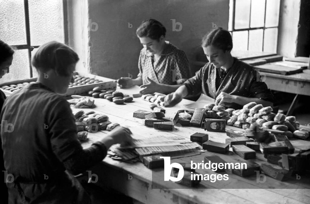 Female staff members of the Deutsche Fettsäurewerke and Maerkische Seifenindustrie company at Witten packing ready produced pieces of soap, Germany 1930s (b/w photo)