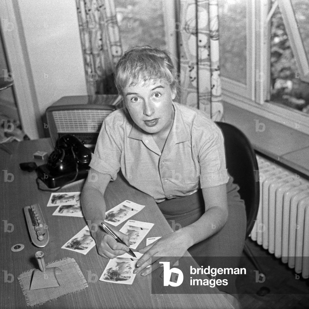 German actress, jazz and schlager singer Dany Mann signing autiograph cards at her hotel room at Hamburg, Germany 1950s