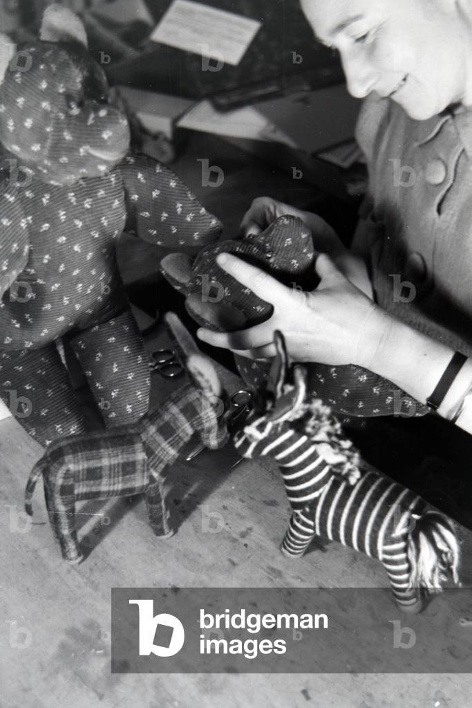 An artisan sewing cuddly toys, Germany 1930s (b/w photo)