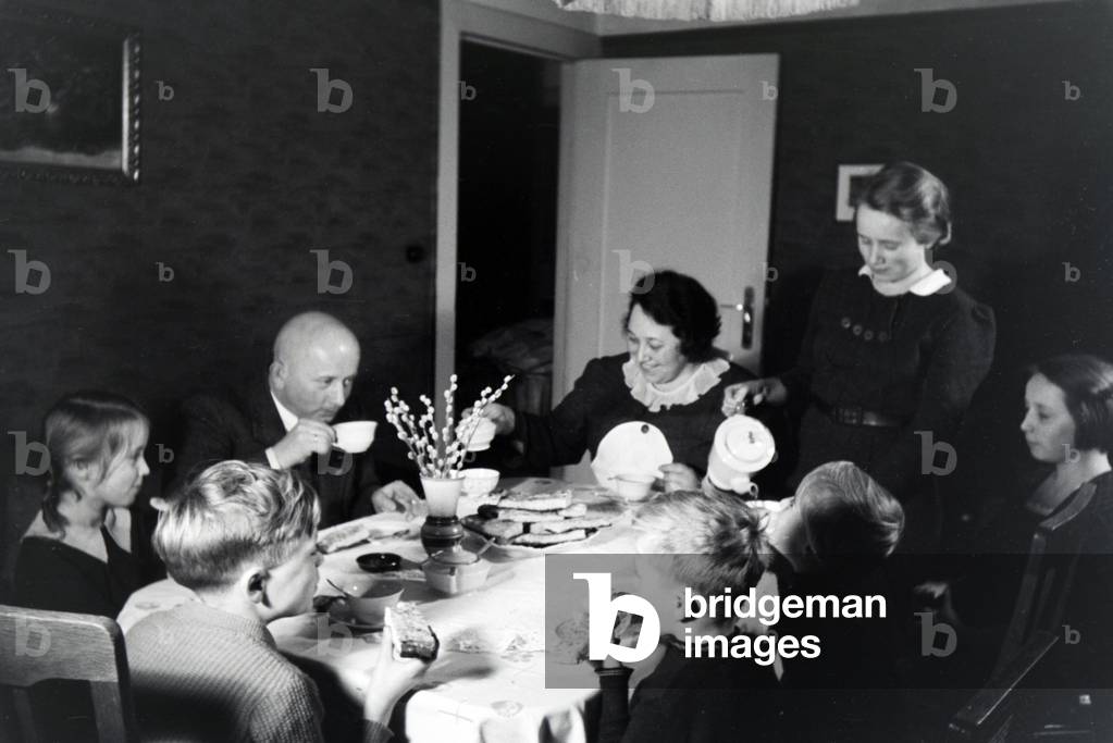 Members of an extended family having coffee and cake, Germany 1930s (b/w photo)
